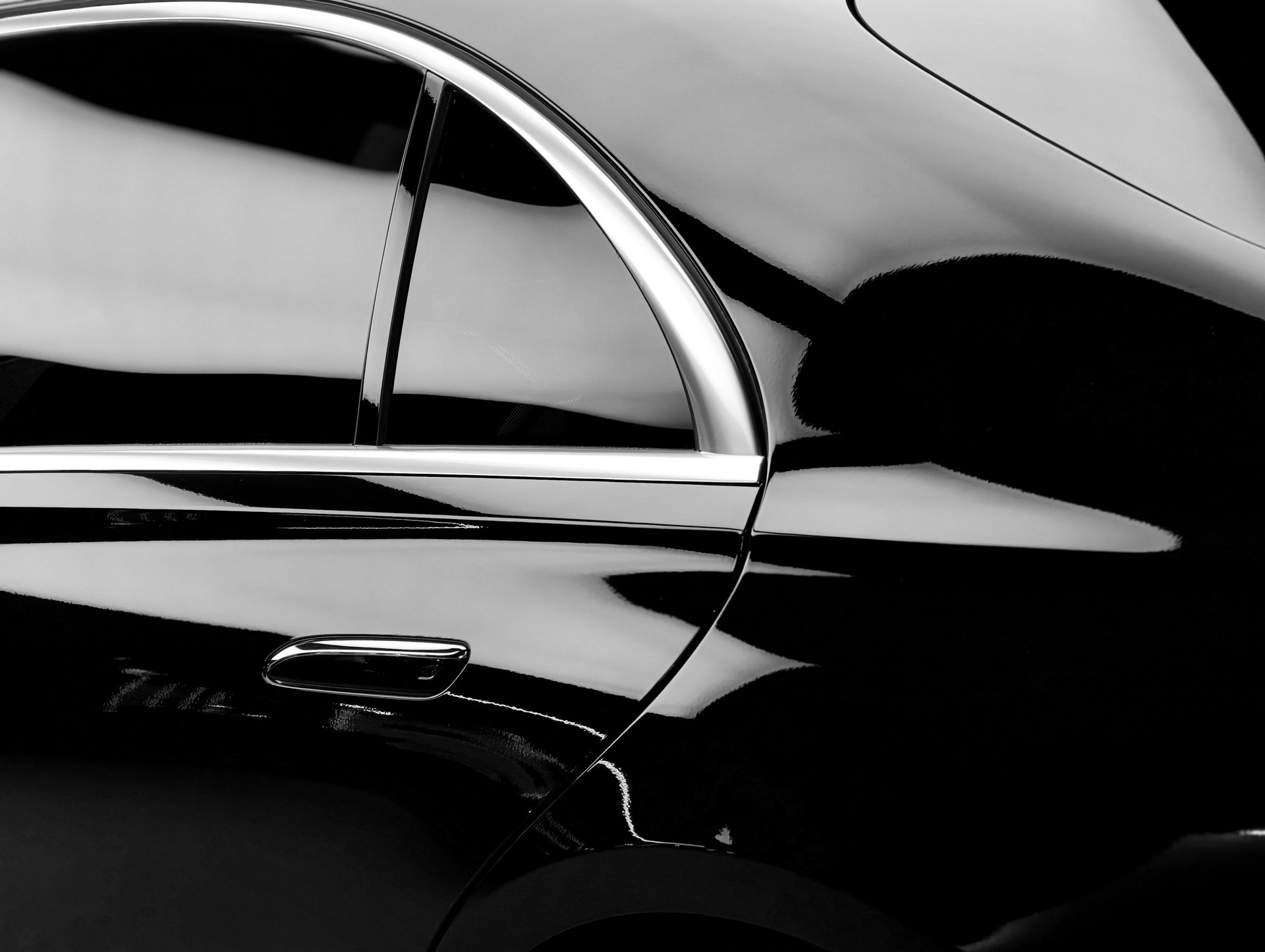 The polished surface of a luxury vehicle reflects light, highlighting its elegant curves and chrome accents